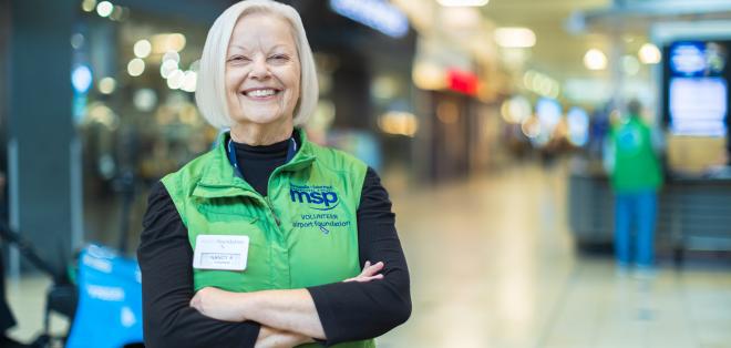 A smiling Airport Foundation Volunteer in the Airport Mall