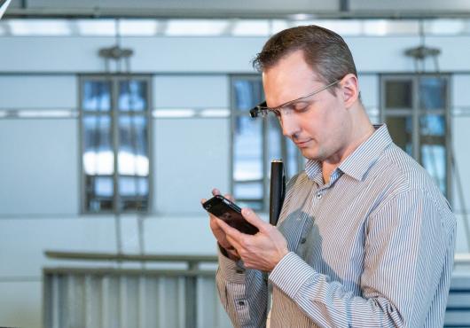 A man wearing Google Glass is talking to an Aira agent over his mobile device